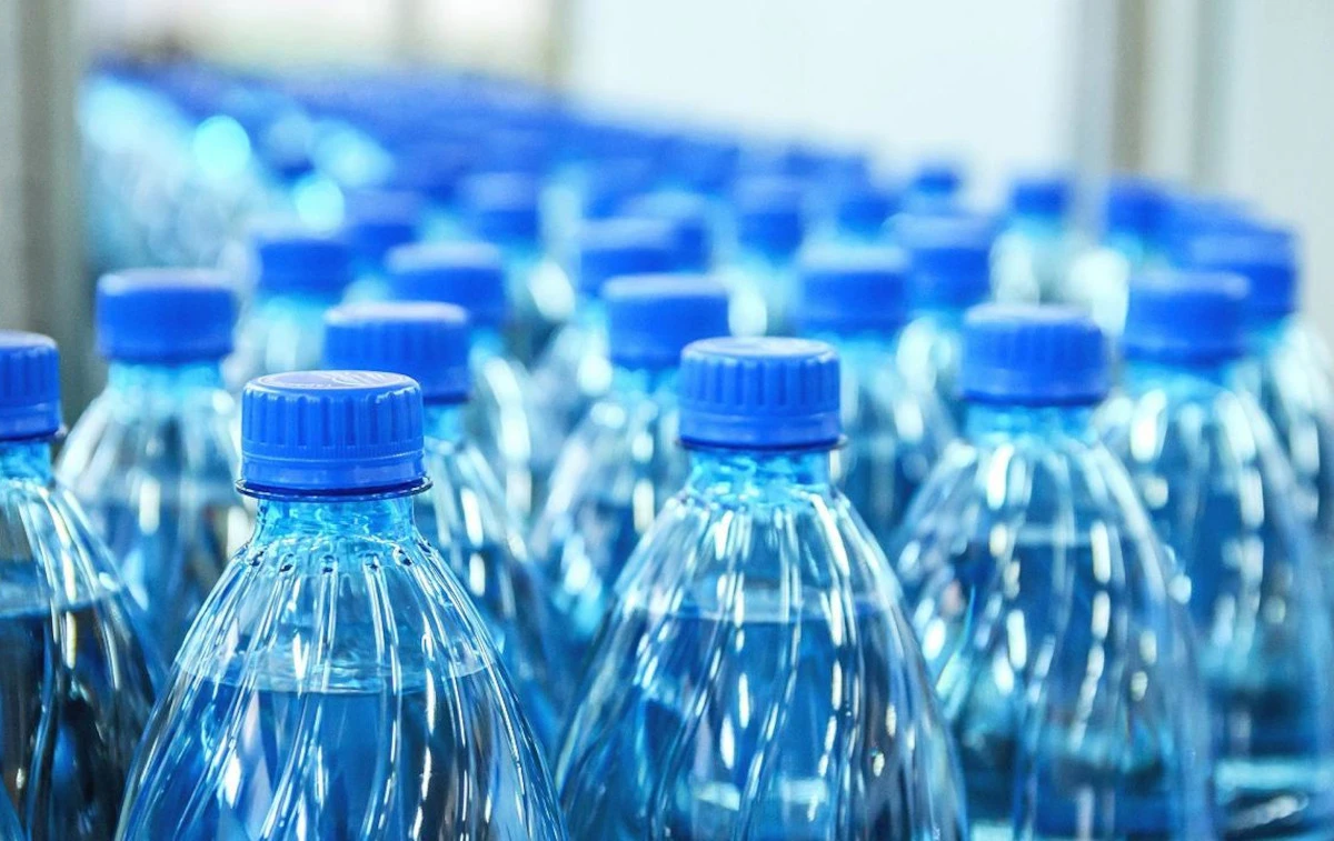 Bottiglia di acqua in plastica accanto a un bicchiere