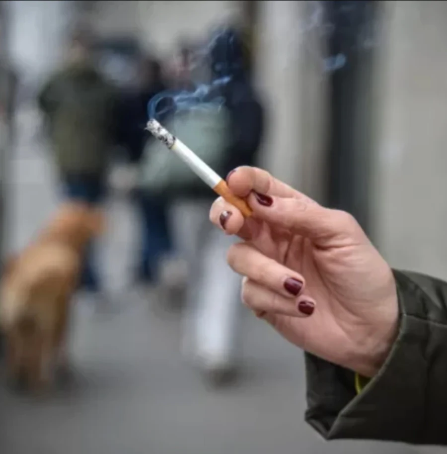 Mani che contano monete a rappresentare l'aumento del costo delle sigarette