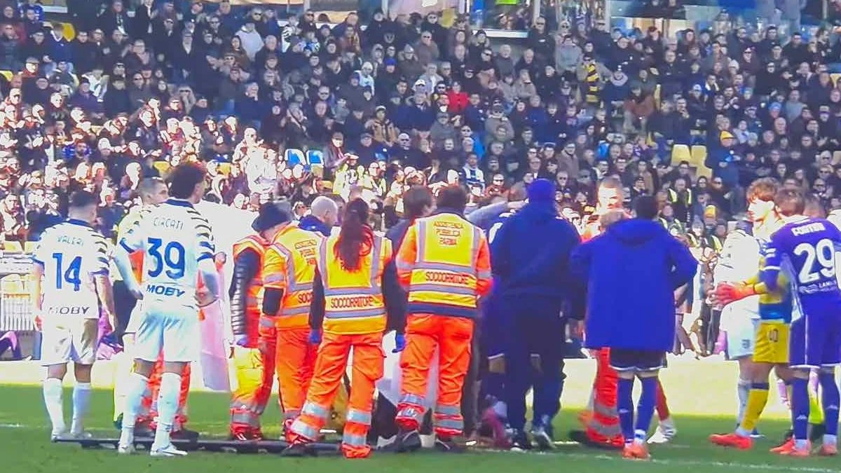 Calciatore a terra dopo uno scontro di gioco durante Parma-Fiorentina allo stadio Ennio Tardini