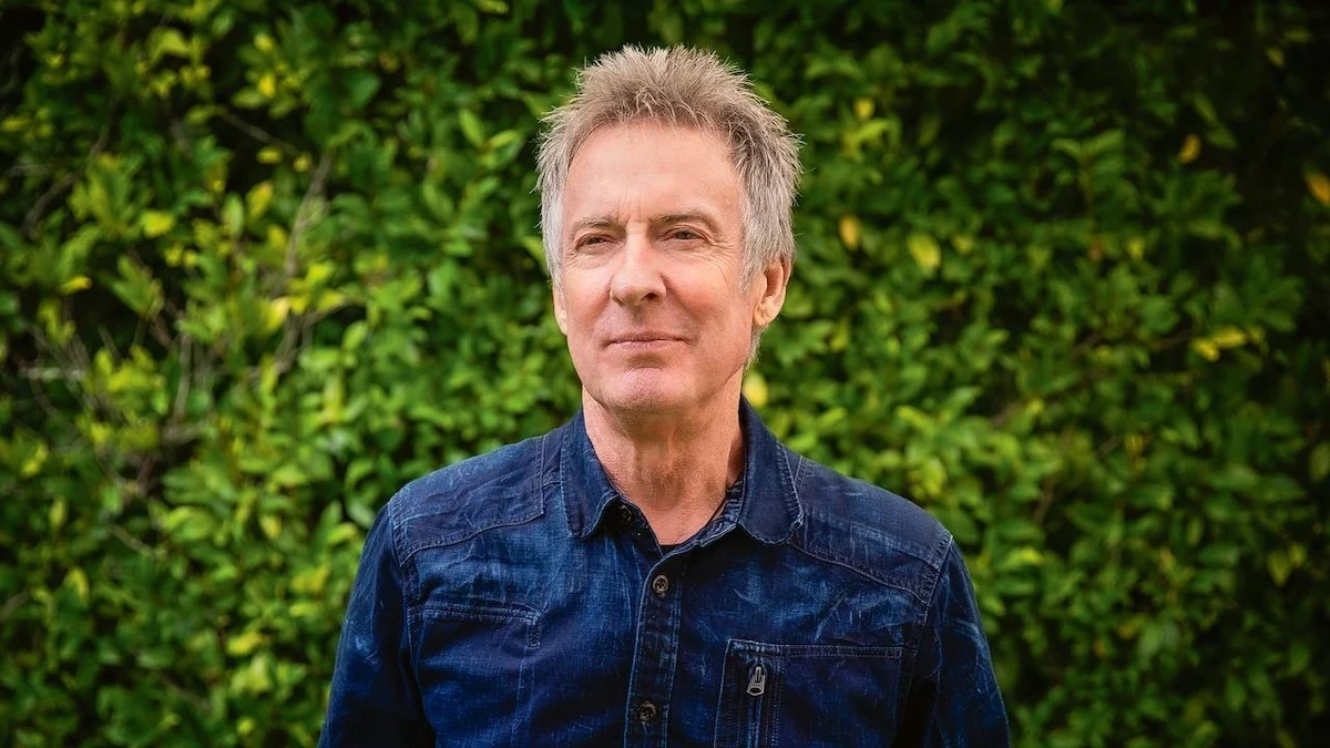 Foto di Rob Hirst sorridente fuori dal palco