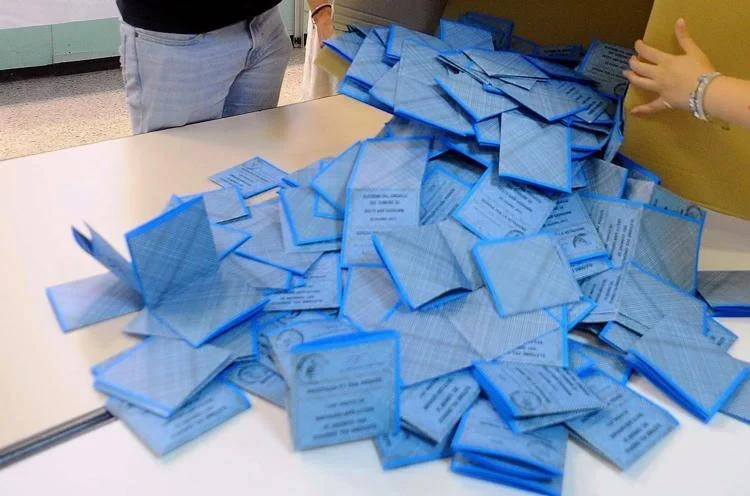 Schede elettorali durante uno spoglio: immagine simbolica delle intenzioni di voto