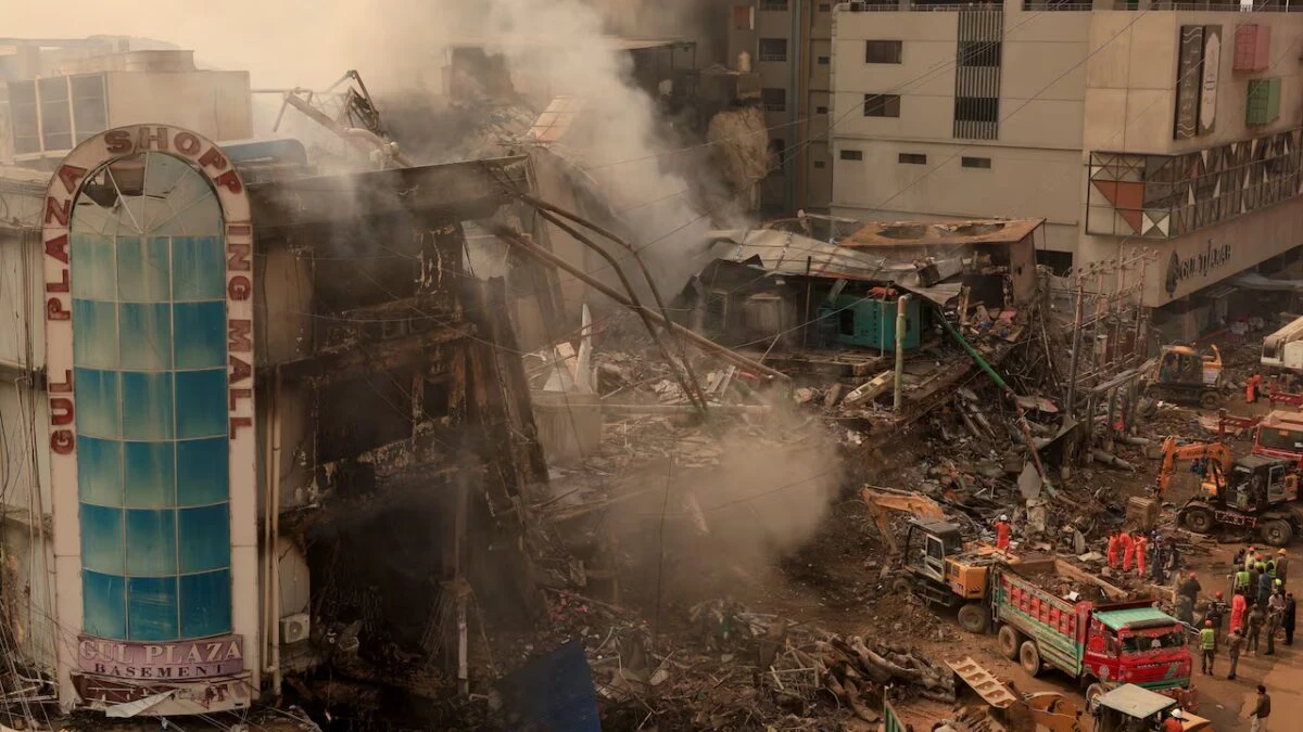 Familiari in attesa e squadre di soccorso dopo l'incendio al centro commerciale Gul Plaza di Karachi