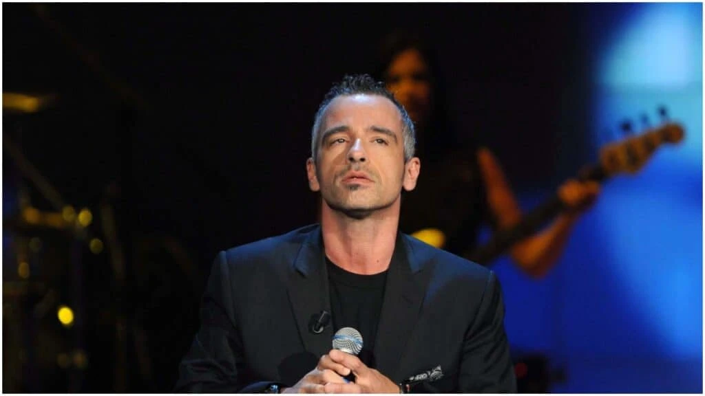 Eros Ramazzotti con microfono in mano durante una performance