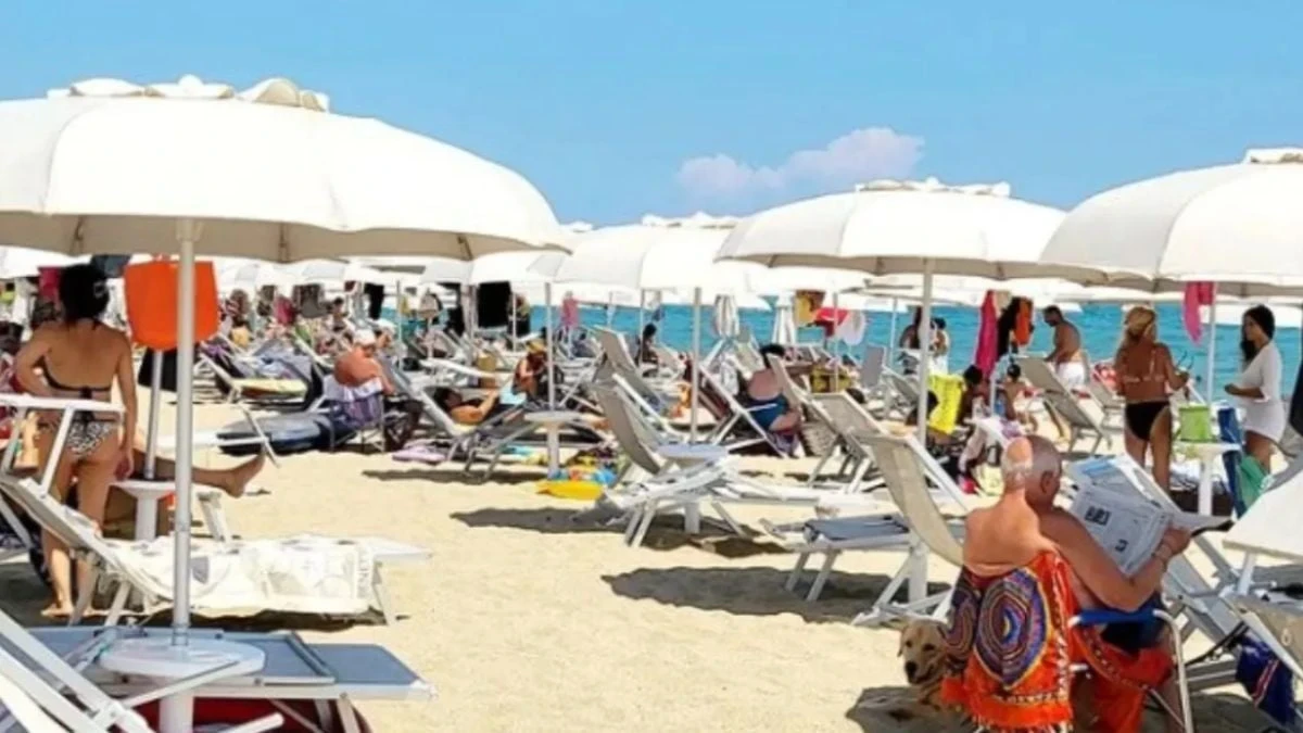 Spiaggia affollata con ombrelloni durante la stagione balneare