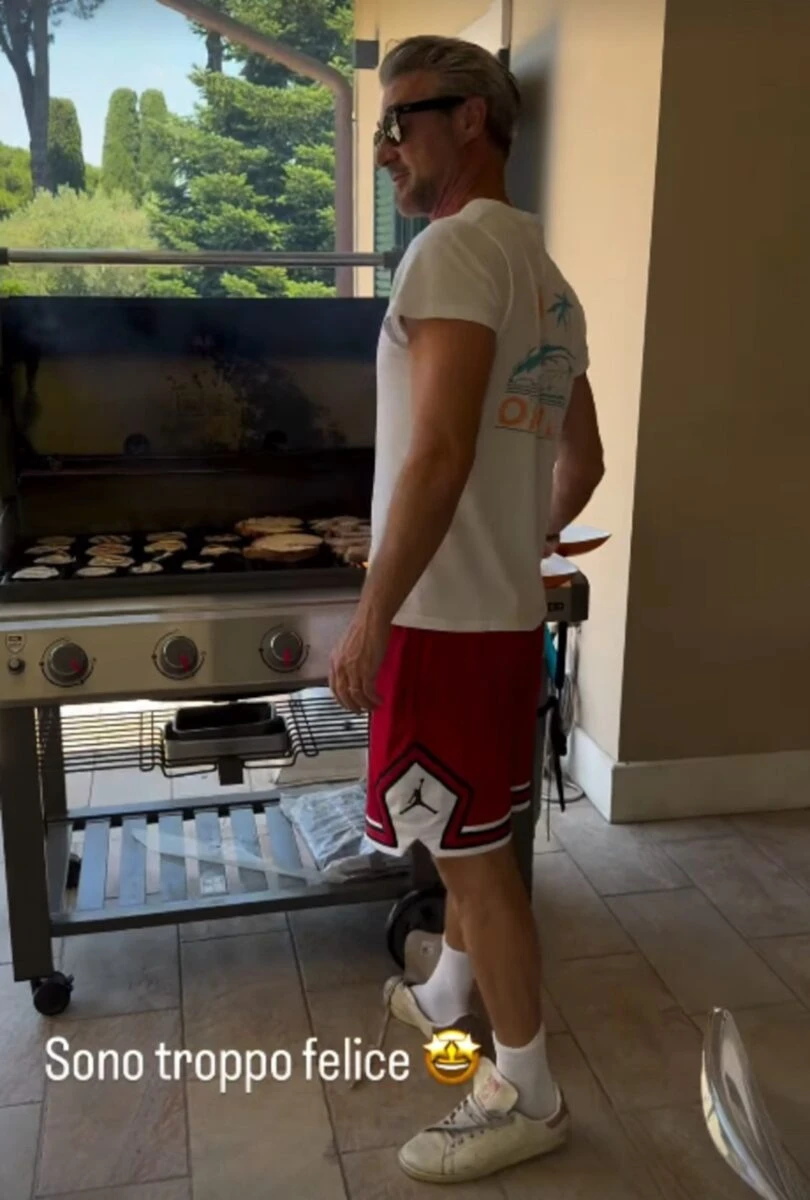 Flavio Montrucchio mentre cucina al barbecue per il compleanno di Alessia Mancini
