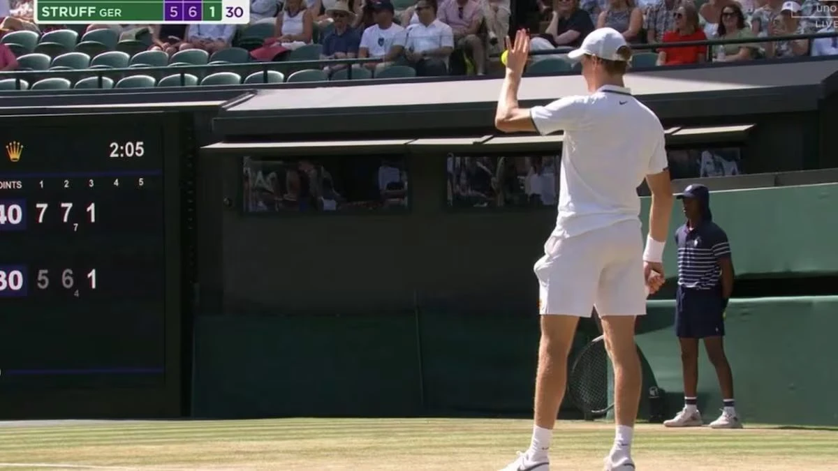 Jannik Sinner saluta un giovane tifoso dagli spalti durante il match a Wimbledon